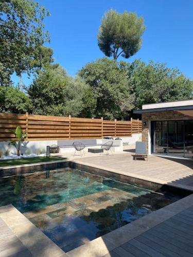 une cour arrière avec une piscine et une maison dans l'établissement Villa moderne avec piscine à 10min Cannes, à Mougins