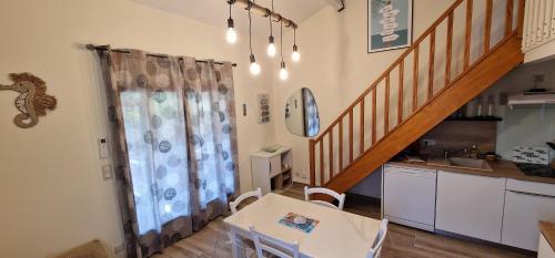 une cuisine avec une table à manger et un escalier dans l'établissement Villa Canto Rano, à Valras-Plage
