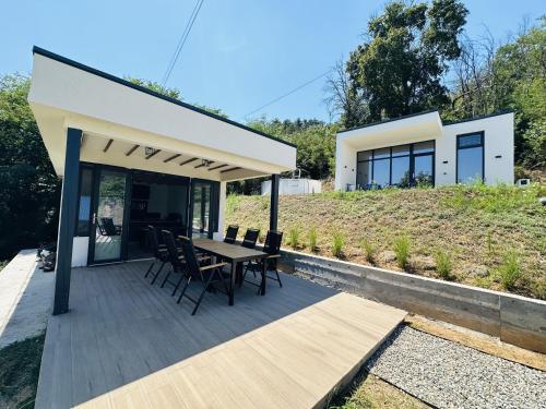a house on a hill with a table and chairs at Nature Nook in Eşelniţa
