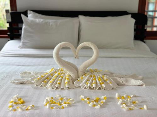 two swans are made out of towels on a bed at Ibiza Bungalows in Haad Yao