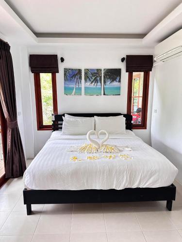 a bedroom with a bed with a heart on it at Ibiza Bungalows in Haad Yao