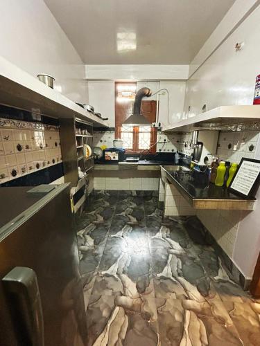 a kitchen with a stone floor in the middle at BimBan's- A cozy little place in Guwahati