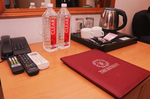 a desk with a bottle of cocacola and a remote control at The Retreat in Mirzāpur