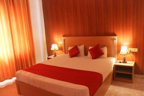 a bedroom with a large bed with red pillows at The Retreat in Mirzāpur