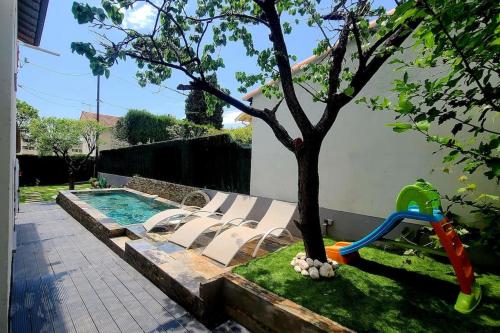 une piscine avec des chaises longues à côté d'un arbre dans l'établissement Escapade Côtière 11 couchages à 5 min des Plages, à Cagnes-sur-Mer
