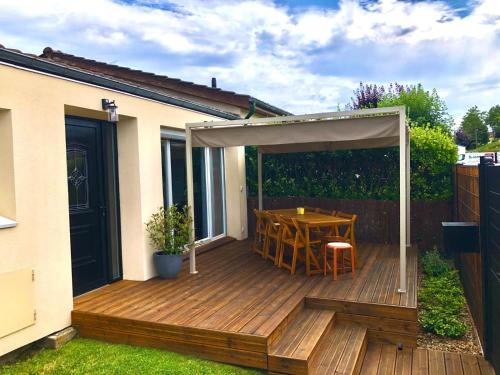 a wooden deck with a table and a canopy at Maison familiale 100m2 in Witry-lès-Reims