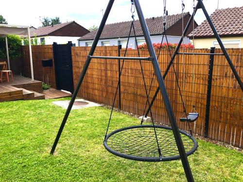 a swing set in a yard with a fence at Maison familiale 100m2 in Witry-lès-Reims