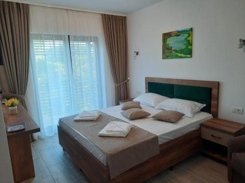 a bedroom with a large bed with two pillows on it at Pensiunea Acvila in Dunavăţu de Jos