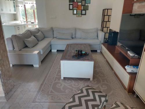 a living room with a couch and a coffee table at Şifne yalı'da 4 oda 9kisi yatak kapasite manzaralı in Cesme