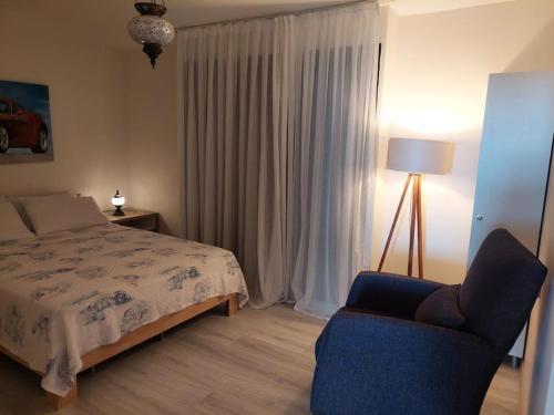 a bedroom with a bed and a chair and a lamp at Şifne yalı'da 4 oda 9kisi yatak kapasite manzaralı in Cesme