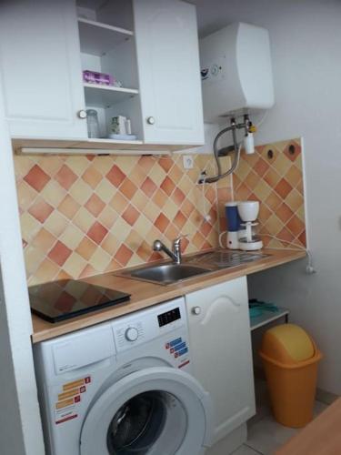 une cuisine avec une machine à laver et un évier dans l'établissement Studio Cabine 4 pers Cap d'Agde avec loggia, au Cap d'Agde