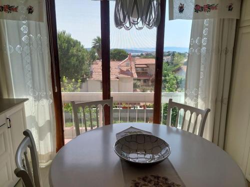 a white table with chairs and a large window at Şifne yalı'da 4 oda 9kisi yatak kapasite manzaralı in Cesme