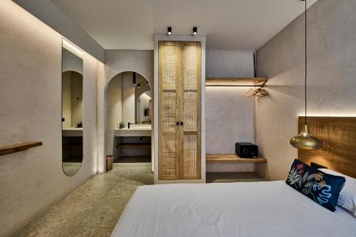 a bedroom with a bed and a bathroom at Ios Resort in Ios Chora