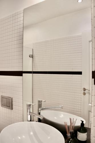 a bathroom with a sink and a tub and a mirror at Green House Apartment in Kaunas