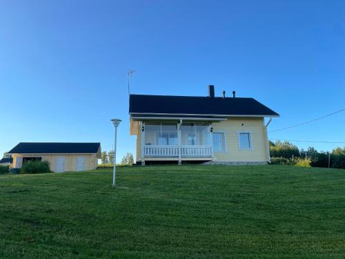 a house on a hill with a large yard at Käylän Helmi in Kuusamo