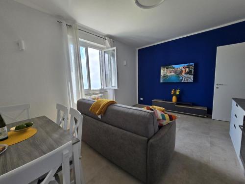 a living room with a couch and a blue wall at Ca' dii Bürsa 2 - HOMY 5 TERRE in Volastra