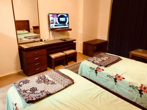 a room with two beds and a vanity and a mirror at قريه اكوا فيو الساحل الشمالى in El Alamein