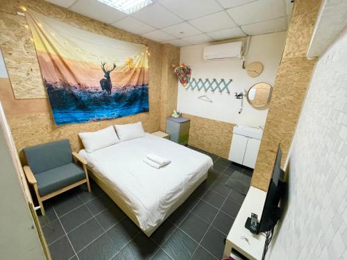 a small room with a bed and a television at Fengchia Oslo in Taichung
