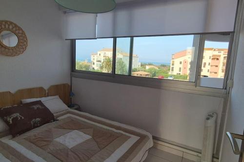 une chambre avec un lit et une grande fenêtre dans l'établissement Appt 4 Pers Lagune & Plage, à Saint-Cyprien