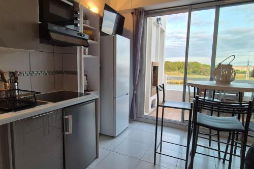 une cuisine avec une table et des chaises ainsi qu'une fenêtre dans l'établissement Appt 4 Pers Lagune & Plage, à Saint-Cyprien
