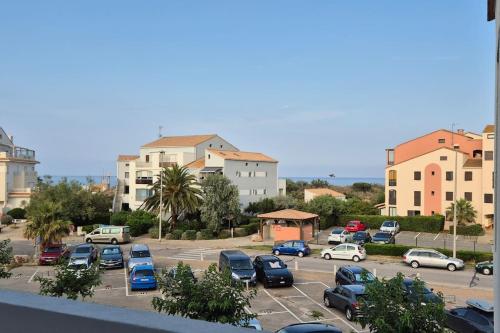 un parking avec des voitures garées sur un parking dans l'établissement Appt 4 Pers Lagune & Plage, à Saint-Cyprien