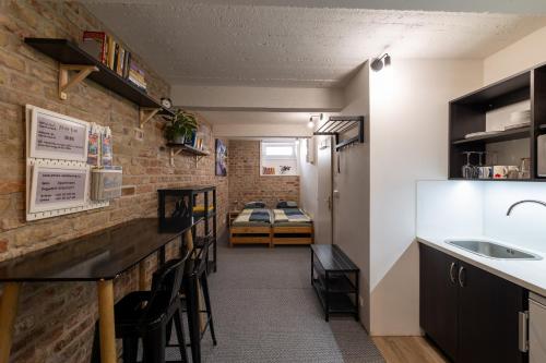 a kitchen with a bar and a room with a bed at VOUSATÁ DÁMA - PS3 - Parking free in Prague
