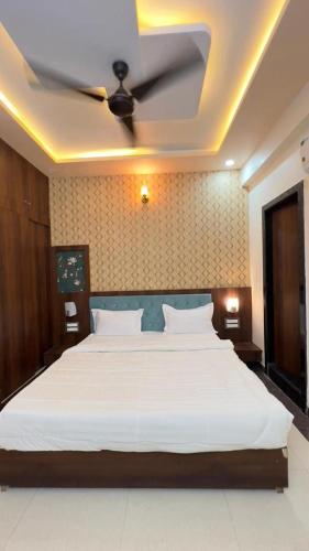 a bedroom with a large bed with a ceiling fan at Hotel Abhinandan Palace in Udaipur