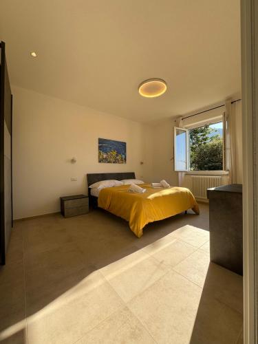 a bedroom with a bed with a yellow blanket at Ca' dii Bürsa 2 - HOMY 5 TERRE in Volastra
