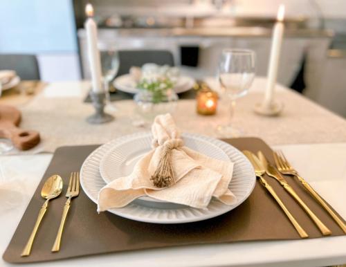 a plate with a napkin on a table with silverware at Gwangan Neogeo House in Busan