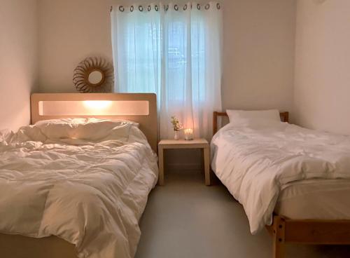 a bedroom with two beds and a window at Gwangan Neogeo House in Busan