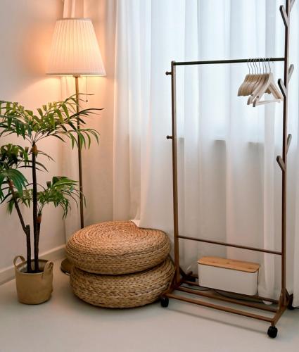 a room with a chair and a lamp and a plant at Gwangan Neogeo House in Busan