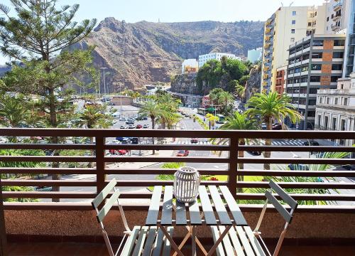 une table et des chaises sur un balcon avec vue sur une ville dans l'établissement Pem House, apartamento con vistas al mar, à Santa Cruz de la Palma