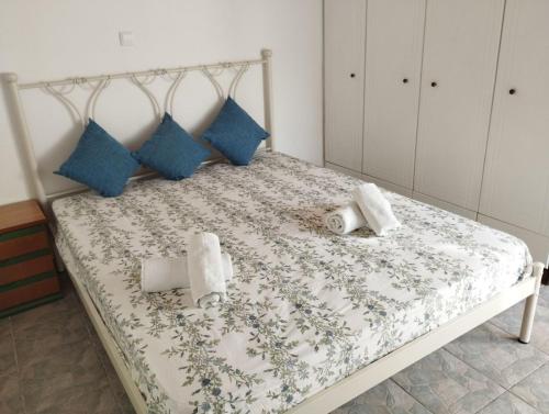 a bed with blue and white sheets and blue pillows at Fay's House in Mesagrós