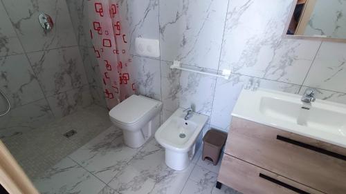 a white bathroom with a toilet and a sink at La Dea del Mare in Ischia