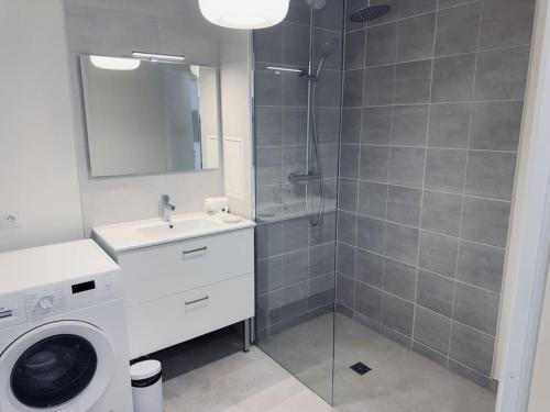 a bathroom with a shower and a washing machine at Somptueux près de Disneyland in Chessy