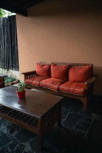 a red couch with red pillows sitting in a room at Riverstone Lodge in Muldersdrift