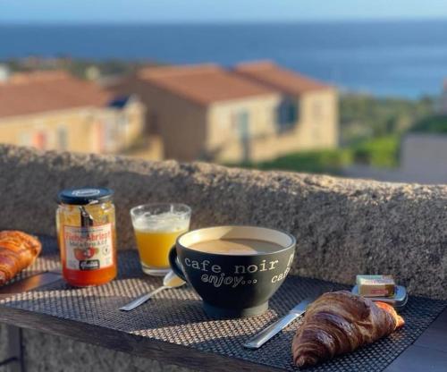 un plateau avec une tasse de café, un croissant et une boisson dans l'établissement Studio vue mer à Sant'Ambroggio, Lumio, à Lumio