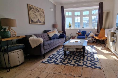 a living room with a purple couch and a table at The Blue house on the wall in Southampton