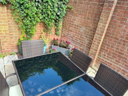 a table with two chairs and a pool of water at The Blue house on the wall in Southampton
