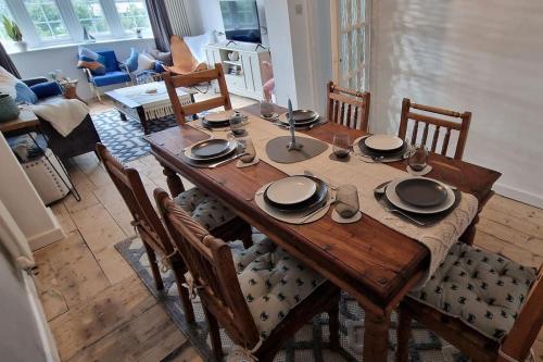 a wooden table with plates and bowls on it in a living room at The Blue house on the wall in Southampton