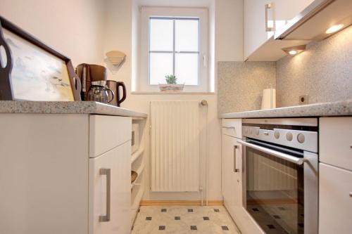 une cuisine avec un évier et une cuisinière dans l'établissement Ferienhaus Möwe, à Ditzum