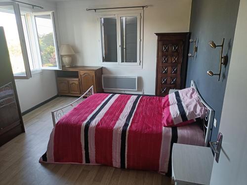 1 dormitorio con 1 cama con manta roja y rayada en Véritable maison de campagne nouvellement rénovée au pied du Lubéron, en Cheval Blanc
