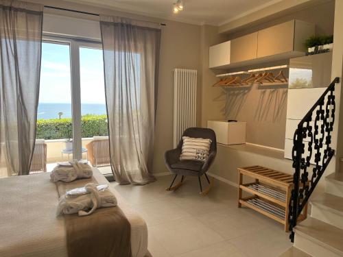 a bedroom with a bed and a chair and a window at IL MARE BLU in Lerici