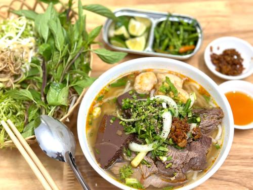 eine Schüssel Suppe mit Fleisch und Gemüse auf einem Tisch in der Unterkunft VILLA KIM GIA ĐÀ LẠT in Da Lat