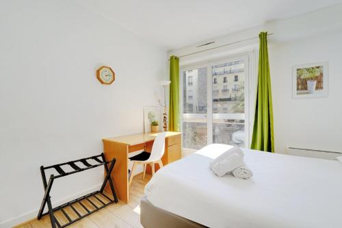 une chambre avec deux lits et un bureau et une fenêtre dans l'établissement Familial Spacieux 2ch avec Parking Prive Sup, à Paris