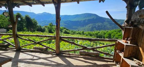 a view from the porch of a house with a wooden fence at Korenishuli Veranda Wine Hotel 45 km from Tsageri in Tsʼageri