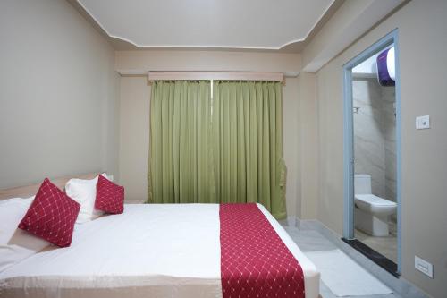 a bedroom with a bed and a green curtain at TheMapleVillageFarmstay in Gangtok