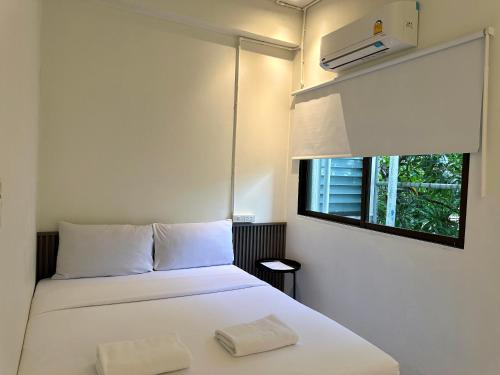 a bedroom with a white bed with a window at My House Guesthouse & Restaurant in Bangkok