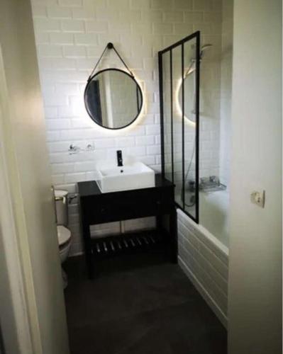 une salle de bain avec un lavabo et un miroir dans l'établissement Magnifique appartement à 10mins de Disneyland Paris avec Parking, à Bailly-Romainvilliers