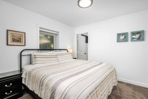 a white bedroom with a bed and a window at Glimmering Sands in Depoe Bay